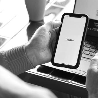 Man holding mobile device with DocuSign on screen